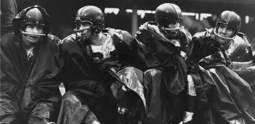 New York Giants quarterback Y.A. Tittle (14) is assisted from the playing  field on Dec. 29, 1963 at Wrigley Field in Chicago by teammate Hugh  McElhenney (39) after Tittle was injured in